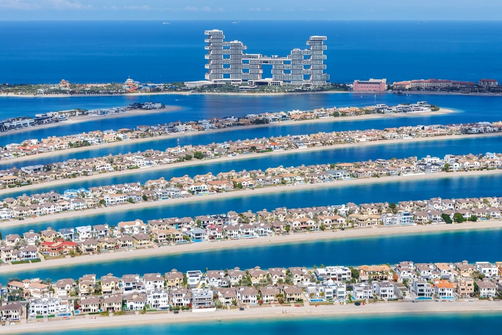 Aerial view of Palm Jumeirah's beachfront villas and waterways with Atlantis The Royal in the distance