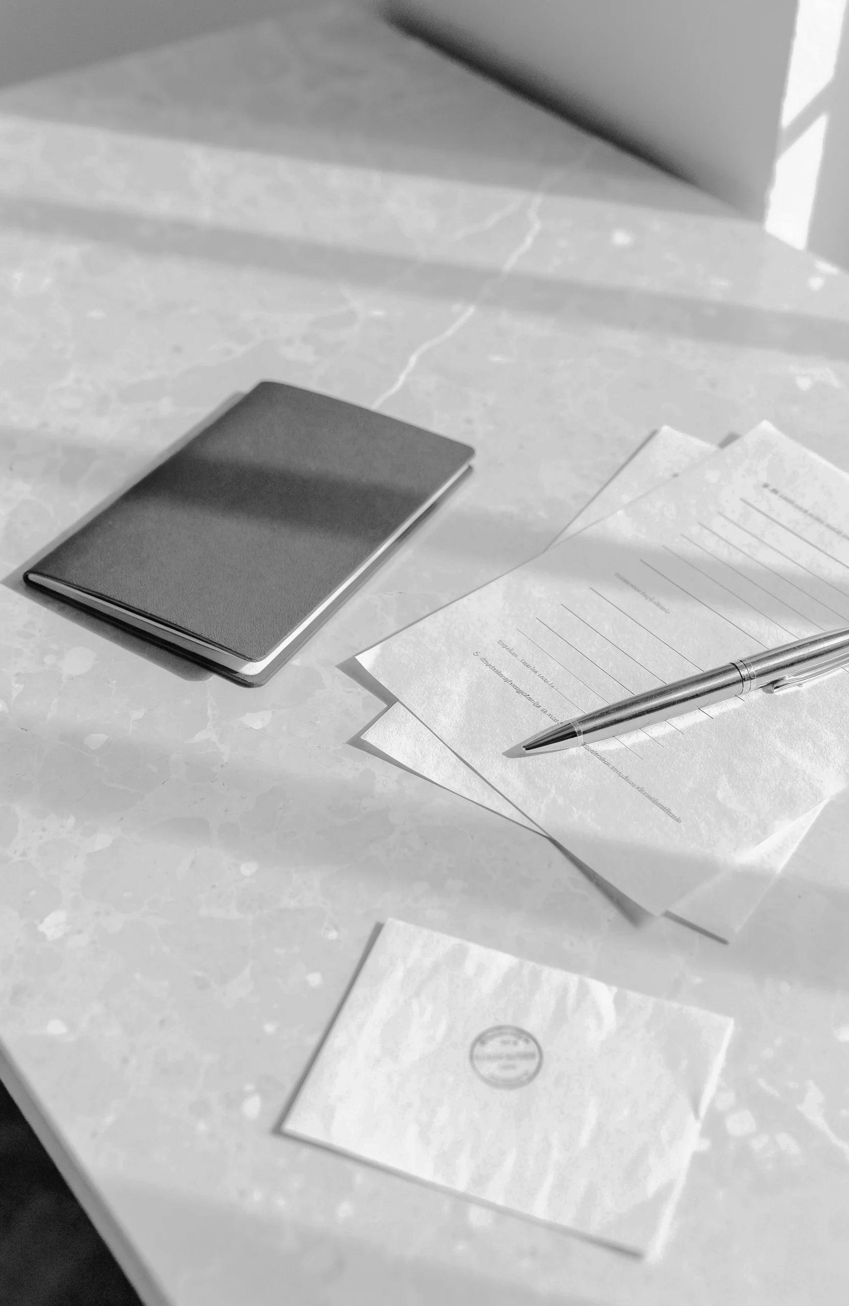 Passport, residency application papers and an immigration stamp on a desk